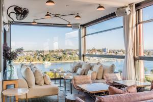 a room with a large window with couches and tables at Hotel Palisade in Sydney