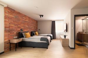 1 dormitorio con 2 camas y pared de ladrillo en Apartamenty Centrum Park, en Zielona Góra