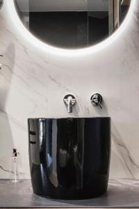 a black sink in a bathroom with a mirror at MaisonMe Boutique Hotel in Bardolino