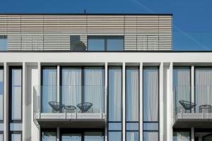 a building with tables and chairs on the balcony at MaisonMe Boutique Hotel in Bardolino