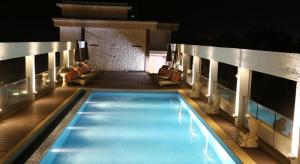 a swimming pool at night on a building at Lemon Tree Hotel Candolim in Candolim