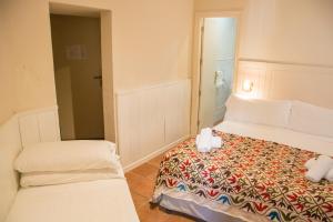 
a bedroom with a white bed and white sheets at Hostal Callejon del Agua in Seville
