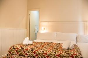 
a bedroom with a white bedspread and white pillows at Hostal Callejon del Agua in Seville
