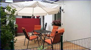 patio con tavolo, sedie e ombrellone di Ferienwohnung an der Almequelle ad Alme