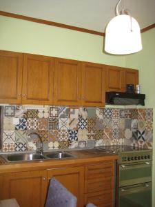 - une cuisine avec des placards en bois, un évier et une cuisinière dans l'établissement Virginia Apartment, à Thessalonique