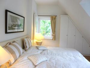 a bedroom with a white bed with a window at Das Gut klein Bollhagen in Wittenbeck