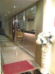 un vestíbulo con un jarrón de flores en un pasillo en California Hotel, en Hong Kong