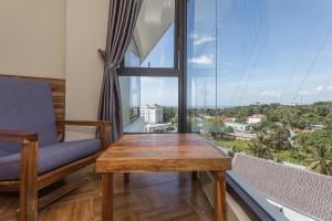 een kamer met een houten tafel en een groot raam bij Golden Daisy Hotel in Phu Quoc
