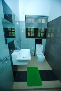 a bathroom with a white sink and a toilet at Kandyan Fo Rest in Kandy