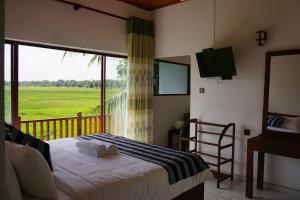 a bedroom with a bed and a balcony with a window at Sunshine Tourist Rest in Anuradhapura