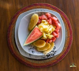a plate of fruit on a wooden table at Migombani Camp in Mto wa Mbu