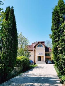 a large house with a driveway in front of it at Pensiunea Ambiance in Piatra Neamţ