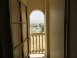 a door leading to a hallway with a view of a building at Al Ferdous Hotel Apartments in Muscat