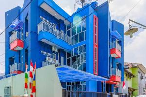 a blue building with balconies on a street at RedDoorz Syariah near Metropolitan Mall Bekasi in Bekasi