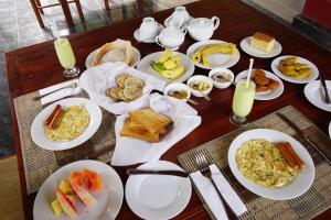 a table with plates of breakfast food on it at Sunshine Tourist Rest in Anuradhapura