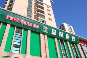 a building with green and red signs on it at Forest Inn (Haikou CRH East Station) in Haikou