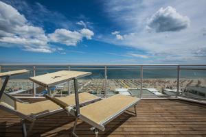 a balcony with a bench and a view of a beach at Bellettini Hotel in Milano Marittima +157 photos