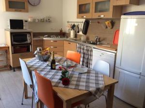 a kitchen with a table and chairs with a table and a refrigerator at Casa dolce casa in Viareggio