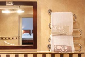 a bathroom with a mirror and towels on a wall at Allegroitalia San Gallo Firenze in Florence