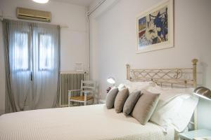 a bedroom with a white bed with pillows at Nautilus Apartments in Parikia