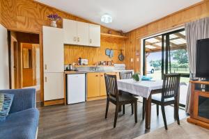 a kitchen and dining room with a table and chairs at Pickering Barn Stay in Tamahere