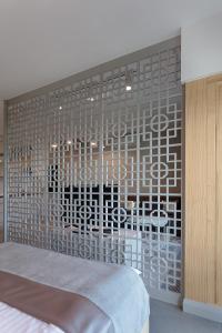 a bedroom with a wall covered in metal mesh at Mennica Residence in Warsaw