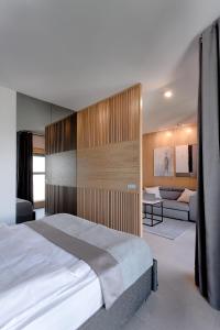 a bedroom with a large bed and a couch at Mennica Residence in Warsaw