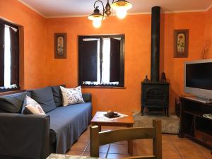 a living room with a blue couch and a stove at Les Piperes in Corao
