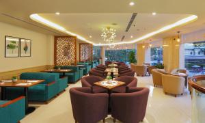 a restaurant with a long line of tables and chairs at Golda Hotel in Ho Chi Minh City