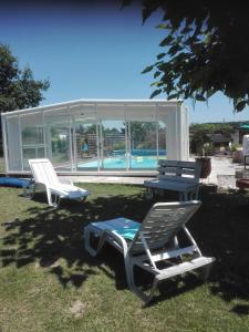 2 chaises longues, une table et une piscine dans l'établissement Le Taruquet, à Eymet