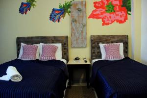 - deux lits assis l'un à côté de l'autre dans une pièce dans l'établissement Casa Akbal B&B, à Mérida