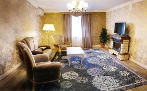 a living room with a couch chairs and a television at Tumar Hotel in Aktobe