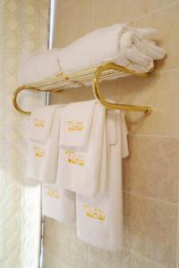 un estante con toallas blancas en el baño en Tumar Hotel, en Aktobe