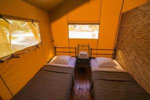 a room with three beds in it with a window at VELA Glamping - Camp Čikat - Lošinj in Mali Lošinj
