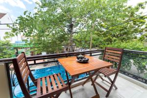 een houten tafel en 2 stoelen op een balkon bij Hoa Thu Homestay in Hội An