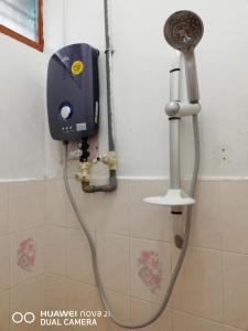 y baño con ducha y cabezal de ducha. en Taiping Guest House en Taiping