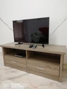 a wooden entertainment center with a flat screen tv on it at Taiping Guest House in Taiping
