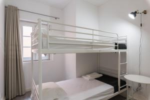 リスボンにあるCity Stays Atalaia Apartmentsの窓付きの客室の白い二段ベッド1台分です。