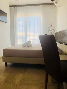 1 dormitorio con cama, escritorio y ventana en Albergo Milazzo Inn AiMori en Milazzo