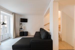 リスボンにあるCity Stays Atalaia Apartmentsのリビングルーム(黒いソファ、階段付)