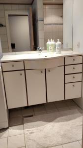 W łazience znajduje się umywalka i lustro. w obiekcie Aalborg City Rooms ApS w Aalborgu