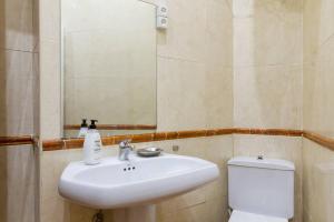 łazienka z umywalką, toaletą i lustrem w obiekcie Cozy Apartment in Plaza Mayor Square by Batuecas w Madrycie +10 zdjęć