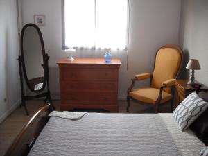 ein Schlafzimmer mit einem Bett, einer Kommode und 2 Stühlen in der Unterkunft Residence Le Vendome in Dijon