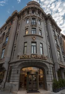a building with a hotel versace sign on it at Hotel Venezia by Zeus International in Bucharest