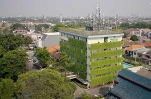 un edificio con plantas verdes a su lado en Apartemen Senayan, en Yakarta