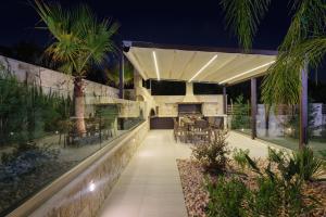 an outdoor kitchen and dining area of a house at night at Villa Thalia in Stalos