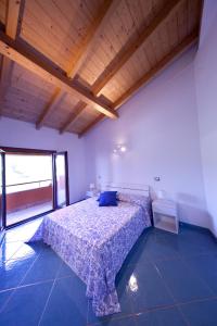 una camera con un letto in una stanza con soffitto in legno di BIANCA - Il mare a Roma a Palo