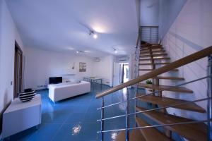 sala de estar con suelo de baldosa azul y escalera en BIANCA - Il mare a Roma, en Palo