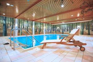 a swimming pool with a reclining chair in a room at Hapimag Ferienwohnungen Braunlage in Braunlage