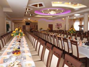 um longo salão de banquetes com mesas e cadeiras longas em Hotel Ostoja em Bobowa